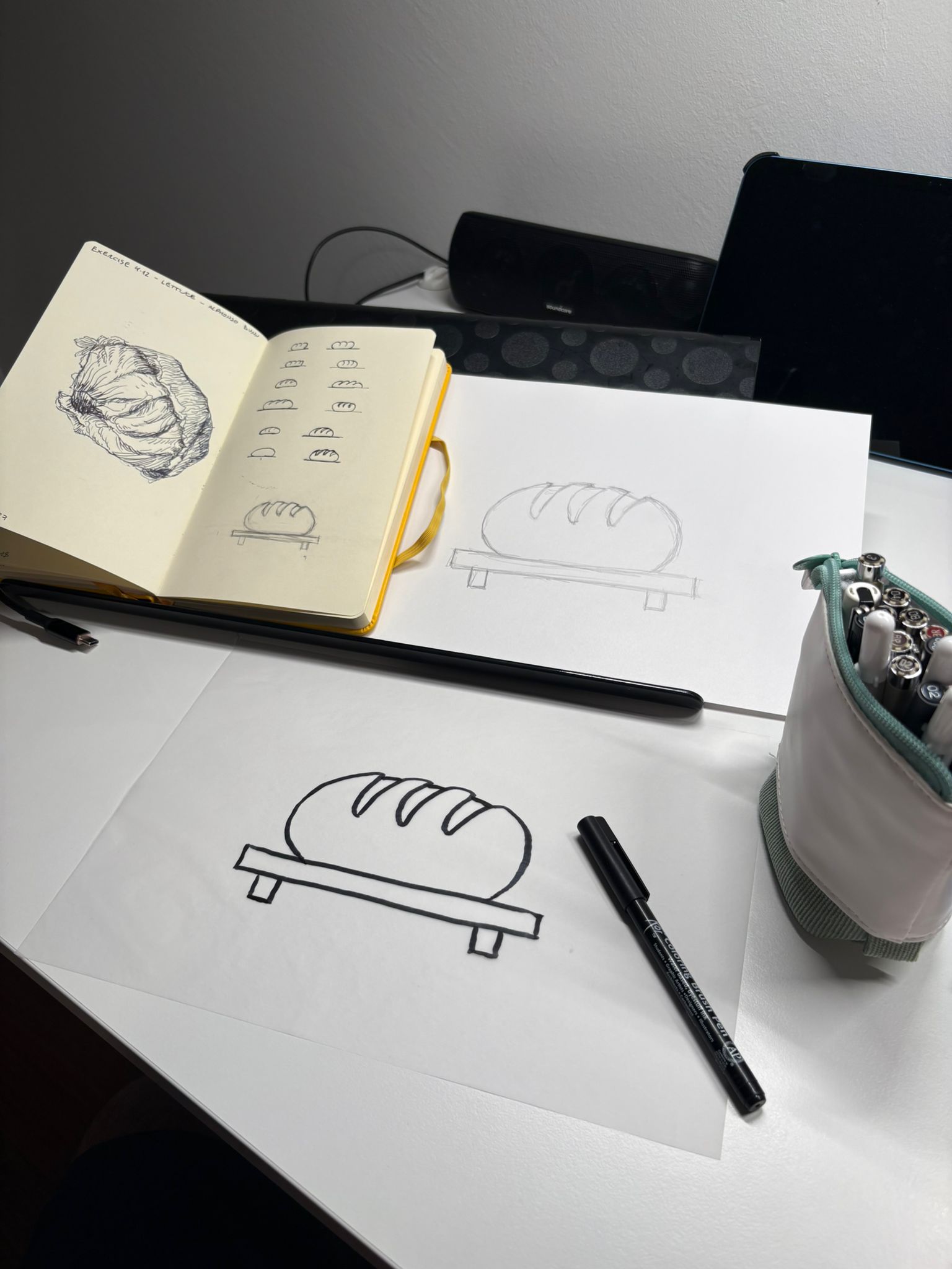 A composite showing initial sketches, a larger pencil drawing, and the final ink art for the bread cover
