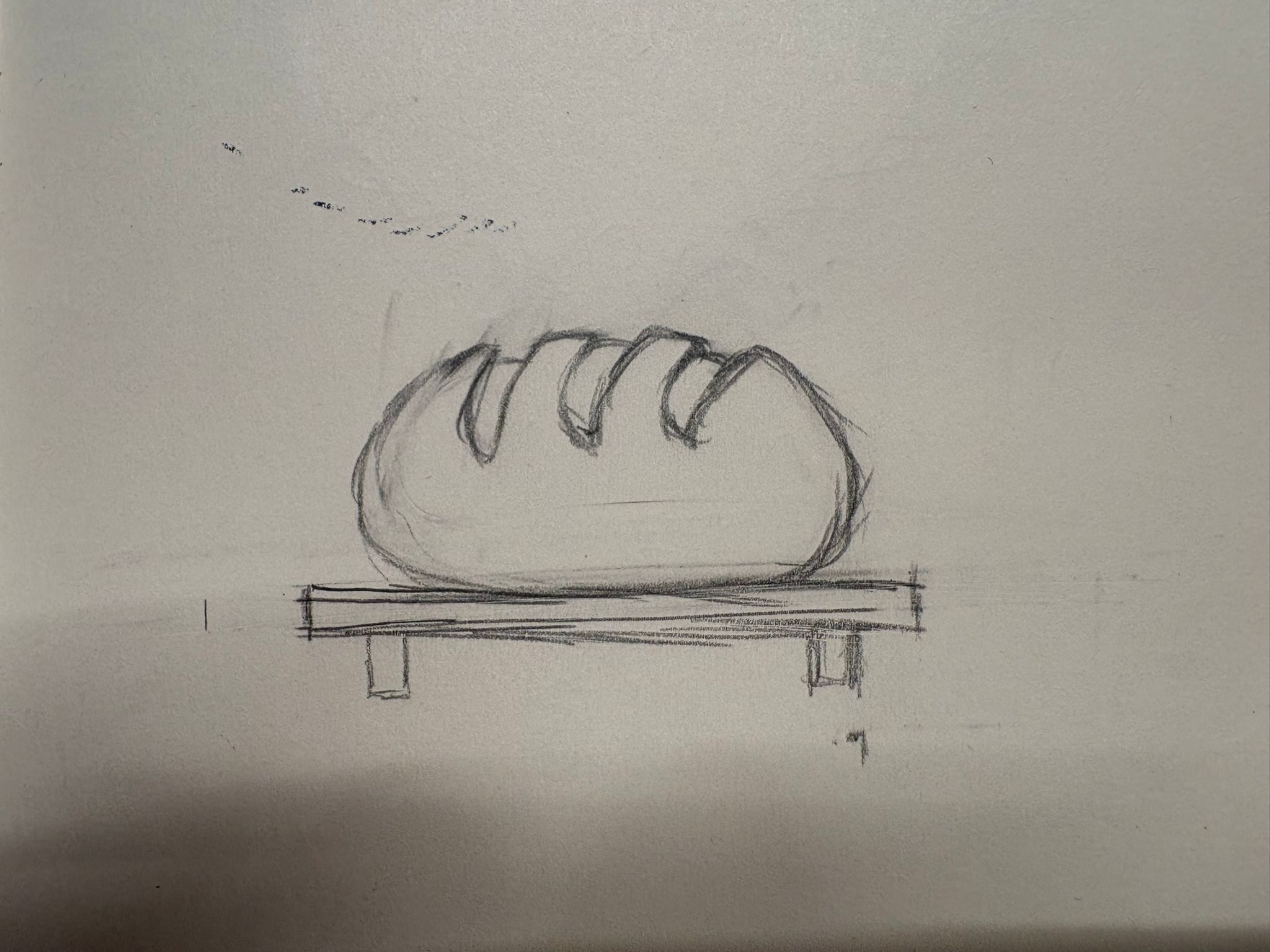A rough pencil sketch of a loaf of bread on a table, in close-up